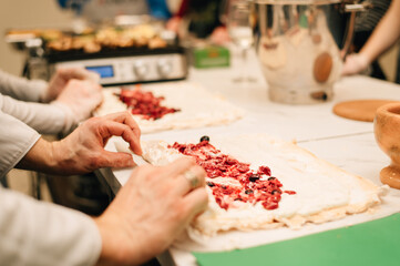A pastry chef rolls up a meringue roll
