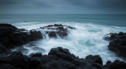 Fototapeta premium Dramatic seascape with crashing waves against rocky coastline under moody sky