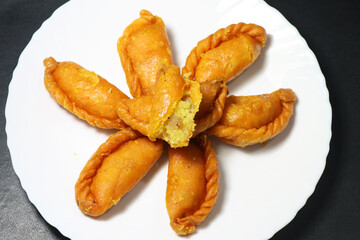 Gujiya or gujia is a popular North Indian sweet of flaky pastries with khoya, nuts stuffing.