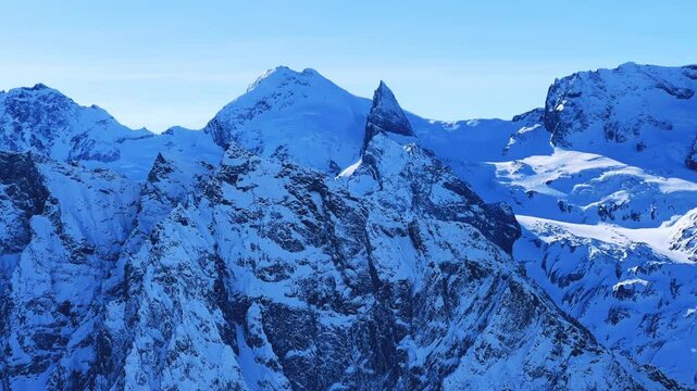 View of Dombay glaciers and mountain peaks in the winter sun. Panorama of the snow-capped Caucasus Mountains in sunny weather. Dombay-Ulgen and Moussa-Achitara mountains. Ski resort in Russia.