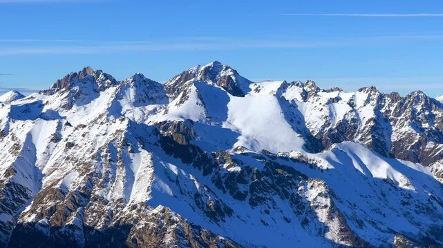 View of Dombay glaciers and mountain peaks in the winter sun. Panorama of the snow-capped Caucasus Mountains in sunny weather. Dombay-Ulgen and Moussa-Achitara mountains. Ski resort in Russia.