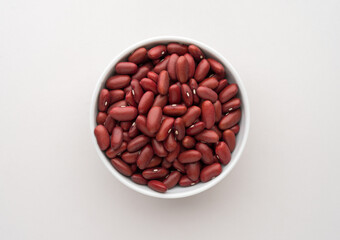Red kidney beans in a white bowl isolated on white background top view
