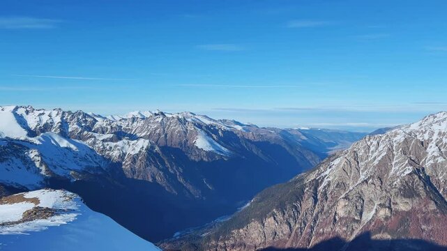 View of Dombay glaciers and mountain peaks in the winter sun. Panorama of the snow-capped Caucasus Mountains in sunny weather. Dombay-Ulgen and Moussa-Achitara mountains. Ski resort in Russia.