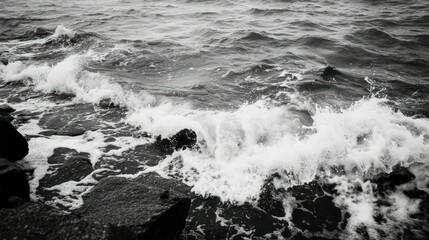 The powerful ocean waves crashing over rocky shorelines in grayscale