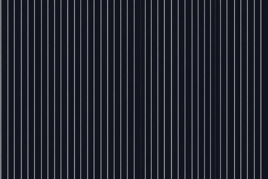 A timeless pinstripe fabric texture background in dark navy with thin white stripes. The sleek, formal design is ideal for business suits, professional attire, and classic interior textiles.