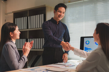 Business partners shaking hands during an office meeting, celebrating their success while colleagues applaud. Fostering teamwork and collaboration, embodying the essence of achievement