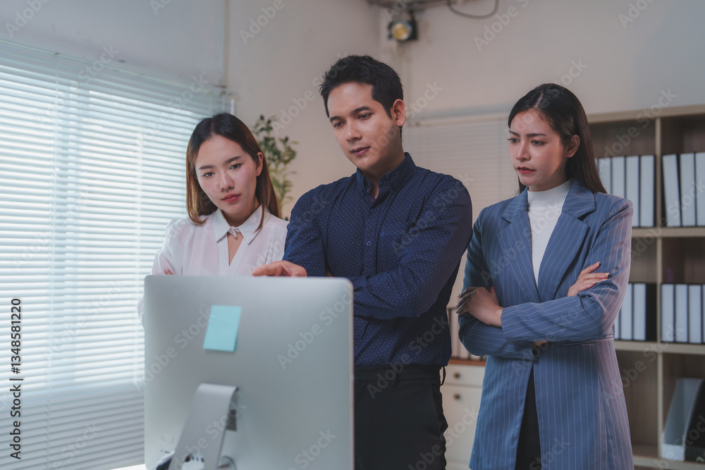 Poster three asian businesspeople are having a discussion in front of a desktop computer, analyzing data an
