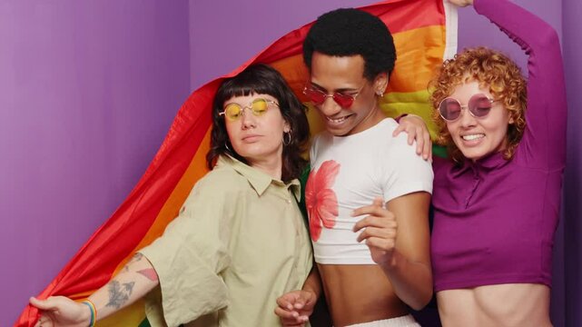 Friends celebrating pride with rainbow flag in photo booth