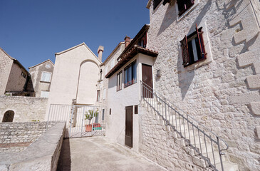 Historic Stone Building with Arched Entrance Under Clear Blue Sky..