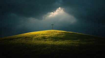 Obraz premium A lone cross stands atop a grassy hill under a dark sky