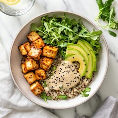 Vibrant quinoa salad with roasted tofu and creamy avocado on a marble surface with refreshing lemon water
