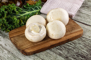 White champignon mushrooms heap over board