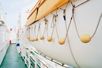 Close-Up of Lifeboat on Ship Deck with Rope and Floats..