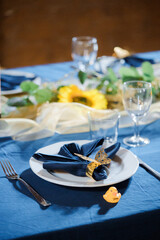 Festive table setting with cutlery and napkin in blue
