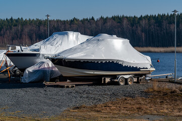 Two motor boats with plastic cover for winter storage