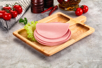 Sliced boiled sausage over board