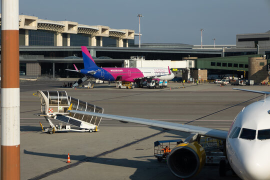 Busy airport scene with commercial airplane of Wizzair on runway during daytime in Milan Malpensa Airport Italy 8 March 2025