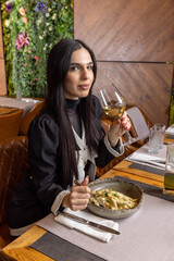 Beautiful woman in a restaurant eating dessert and drinking wine