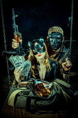 A blonde woman, dressed in a sleek black leather outfit and wearing a cat-like mask sitting beside a duffel bag with gold bars and dollar bills. Behind her, a muscular man in black mask grips an AK-47