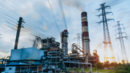 Obraz premium Industrial Power Plant with Pollution: An industrial power plant emitting smoke into the sky, captured amidst high-voltage power lines.