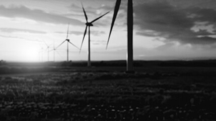 Harnessing the Wind: A monochrome scene showcases wind turbines against a dramatic sky, symbolizing clean energy and sustainable power generation.