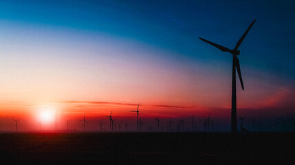 Obraz premium Wind turbines in silhouette against a dramatic sunset sky