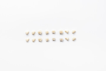 Dental teeth crowns for dental prosthetics, top view. Dentist desk, white background