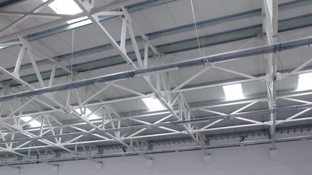 White metal roof structure with skylights in modern warehouse