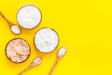 Different kind of sea salt in wooden bowls with spoon, top view. Salt for spa, salt baths or cooking