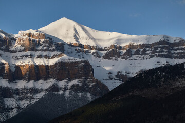 The snow-covered Mondarruego Walls in winter, rising majestically in the Ordesa and Monte Perdido National Park. A stunning frozen landscape in the Spanish Pyrenees