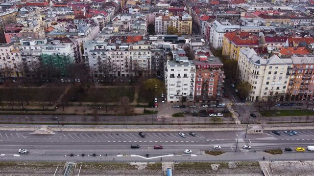 Aerial establishing along roads lining Danube River, Budapest cityscape and transportation network