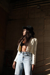 Fototapeta premium Stunning African American woman wearing casual clothing and posing outdoor. Vertical.