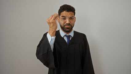 Young hispanic man wearing glasses and a gown makes an italian gesture against an isolated white...
