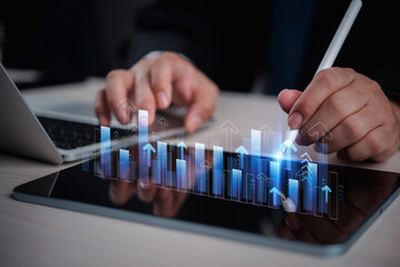business man analyzing digital financial charts and growth trends on a tablet, highlighting the...