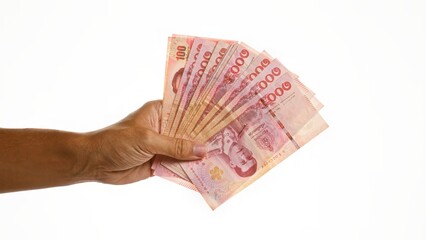 Hand holding thai baht money isolated over white background showing currency and finance in thailand