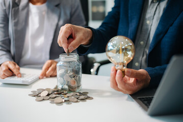 Showcasing innovation and finance. Business professionals with a glowing light bulb, coins,
