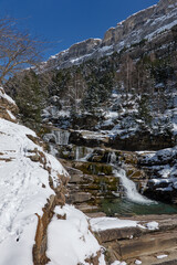 The Soaso Steps, a breathtaking series of waterfalls in the Ordesa Valley, Ordesa and Monte Perdido National Park, completely covered in snow during winter. A magical frozen landscape in the Spanish P