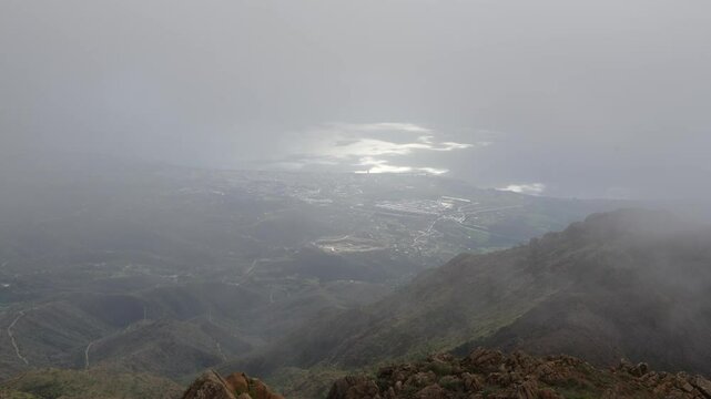 Fog covering estepona city from sierra bermeja mountain range. Fog slowly covering estepona city from sierra bermeja mountain range in costa del sol, andalusia, spain