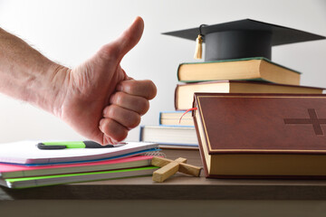 Religious educational material and hand with OK gesture