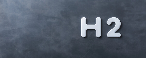 A minimalistic image featuring the chemical symbol "H2" on a textured dark surface.