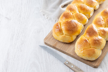 Traditional Easter braided bread. Tsoureki braid on white wooden table. Copy space