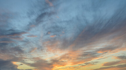 Vibrant sunset hues blend seamlessly across the sky at dusk over tranquil waters