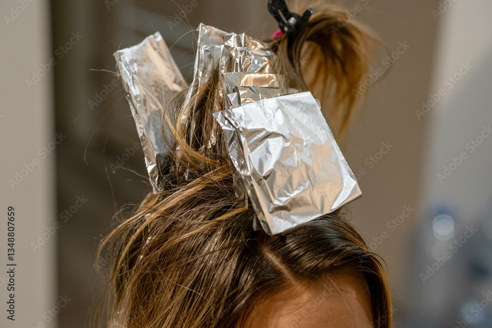 Poster hair coloring process in a salon using foil to create highlights for a stylish look