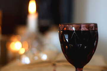 Books, lit candles, red wine, snacks and various deocration on the table. Dark academia or Halloween concept. Selective focus.