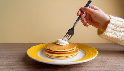 柔らかな光の中で、パンケーキと向き合うホワイトカーディガンが描くリラックスした朝食の時間。

