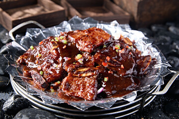 Grilled beef ribs in tin foil with black pepper sauce