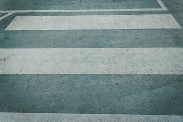 Fototapeta premium Pedestrian crossing lines on pavement in urban area during daylight hours