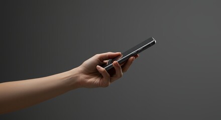 Hand holding mobile phone for communication in studio against dark background