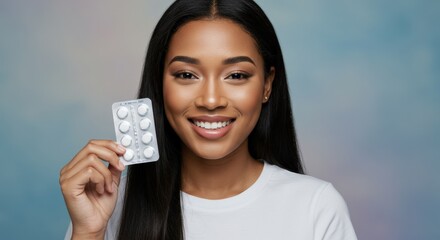 Happy woman with long hair holding a blister pack of pills, smiling brightly with a positive and calm expression.