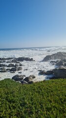 Breathtaking view of Chile’s Pacific coast, featuring rugged rocks, golden sandy beach, and waves under a bright sky. Perfect for travel, nature, and coastal landscapes.